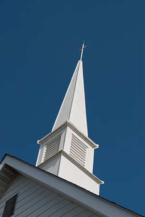 A majestic white steaple towers into the sky over PFC Church.